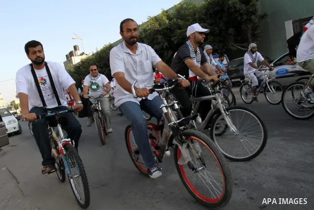 Members of the aid convoy 'Miles of Smiles 4' ride bicycles in a rally to express solidarity with Palestinian people after they entered Gaza through the Rafah border crossing between Egypt and southern Gaza Strip, on Aug...