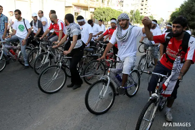 Members of the aid convoy 'Miles of Smiles 4' ride bicycles in a rally to express solidarity with Palestinian people after they entered Gaza through the Rafah border crossing between Egypt and southern Gaza Strip, on Aug...