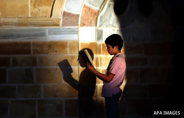 Palestinian boys read the Koran at the al-Omari mosque in Gaza City on the first day of the Muslim holy fasting month of Ramadan on 01 August 2011. Muslims throughout the world are celebrating the holy fasting month of R...