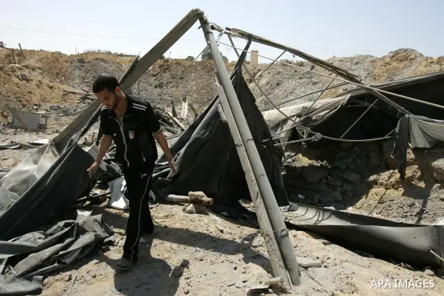 A Palestinians man inspects the damage outside a smuggling tunnel following an overnight Israeli airstrike in Rafah, on the border between Egypt and southern Gaza Strip, Tuesday, Aug 2, 2011. Israel bombed the tunnel in...