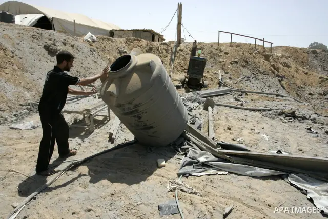 A Palestinians man inspects the damage outside a smuggling tunnel following an overnight Israeli airstrike in Rafah, on the border between Egypt and southern Gaza Strip, Tuesday, Aug 2, 2011. Israel bombed the tunnel in...