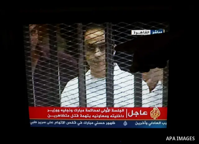 This video image taken from Egyptian State Television shows the sons of Hosni Mubarak stand inside the cage of mesh and iron bars in a Cairo courtroom Wednesday Aug. 3, 2011 as his historic trial began on charges of corr...