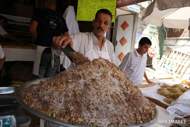 A Palestinian vendor during equipping the pistachio used for the traditional Qatayef on a fasting day of Ramadan in the West Bank city of Ramallah, on Aug. 3, 2011. Muslims around the world abstain from eating, drinking...