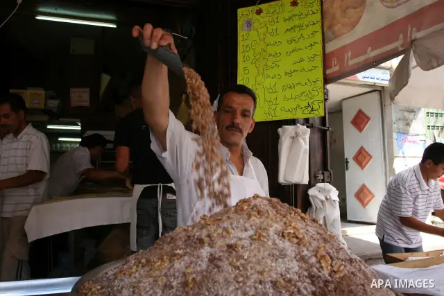 A Palestinian vendor during equipping the pistachio used for the traditional Qatayef on a fasting day of Ramadan in the West Bank city of Ramallah, on Aug. 3, 2011. Muslims around the world abstain from eating, drinking...