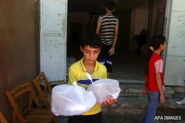 A Palestinian boy carries the meal " free food" for 'Iftar', at charity in Gaza city on Aug. 3, 2011. where provides a free meal all the year round to poor Muslims during the holy fasting month of Ramadan, when observant...