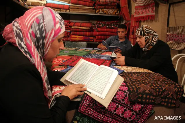 Palestinian women read the holy koran at a shop in the West Bank city of Hebron August 3, 2011. Muslims around the world abstain from eating, drinking and conducting sexual relations from sunrise to sunset during Ramadan...