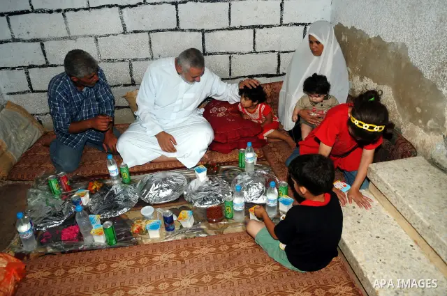 Palestinian Prime Minister in Gaza Strip, Ismail Haniya during eating the meal of "Iftar" with a poor family in the holy fasting month of Ramadan at al-Shati refugee camp beach, western Gaza city on Aug. 3, 2011. Photo b...