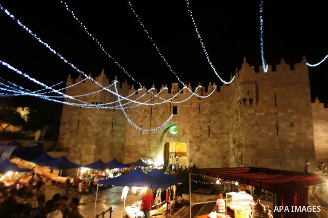 Palestinians stand under decorations in the nights of the holy month of Ramadan near Damascus Gate in Jerusalem's Old City on Aug. 3, 2011. Muslims around the world abstain from eating, drinking and conducting sexual rel...