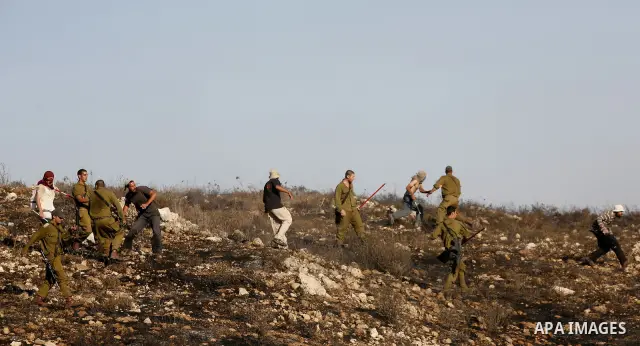 Israeli soldiers break up a fight between Jewish settlers and Palestinians over farming land between the Jewish settlement of Bracha and the nearby West Bank village of Burin, near Nablus, Thursday, Aug. 4, 2011.The IDF...