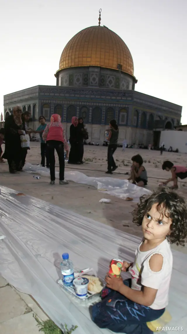 Muslim Palestinians wait to receive their iftar meals donated by a charity in the courtyard of Jerusalem's Al-Aqsa mosque, Islam's third holiest shrine, just before sunset on August 4, 2010. Iftar is the evening meal wit...