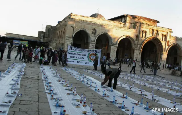 Muslim Palestinians wait to receive their iftar meals donated by a charity in the courtyard of Jerusalem's Al-Aqsa mosque, Islam's third holiest shrine, just before sunset on August 4, 2010. Iftar is the evening meal wit...