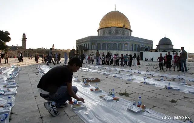 Muslim Palestinians wait to receive their iftar meals donated by a charity in the courtyard of Jerusalem's Al-Aqsa mosque, Islam's third holiest shrine, just before sunset on August 4, 2010. Iftar is the evening meal wit...