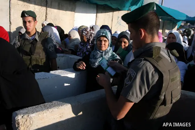 Israeli border policemen check the IDs of Palestinian worshippers as they waiting in line to pass at Qalandia checkpoint that leads from the West Bank town of Ramallah to Jerusalem on Aug. 5, 2011, in order to attend the...