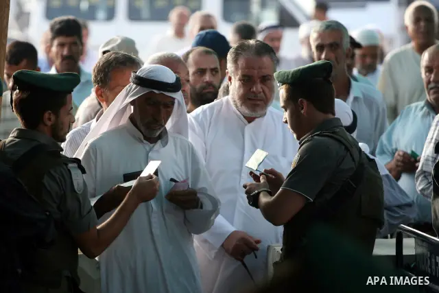 Israeli border policemen check the IDs of Palestinian worshippers as they waiting in line to pass at Qalandia checkpoint that leads from the West Bank town of Ramallah to Jerusalem on Aug. 5, 2011, in order to attend the...