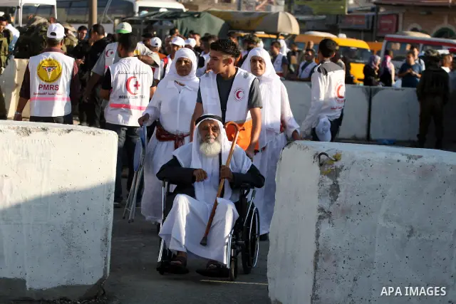 A Palestinian old man sits on his wheelchair waiting to cross the Qalandia checkpoint on their way to pray at the Al Aqsa Mosque on the first Friday of the Muslim holy month of Ramadan, at the Qalandia checkpoint between...