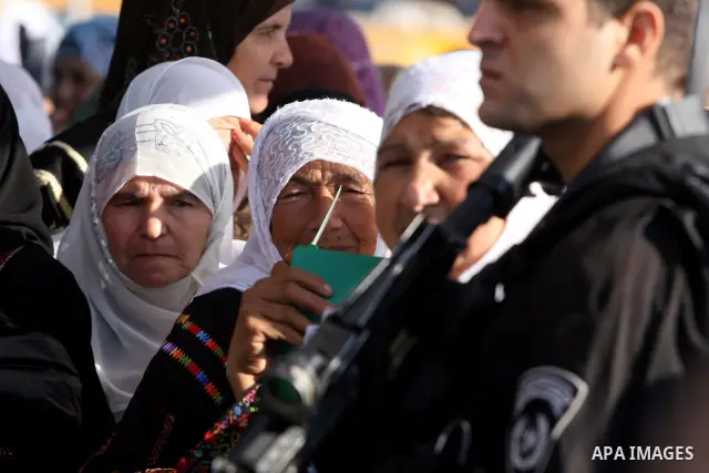 Israeli border policemen check the IDs of Palestinian worshippers as they waiting in line to pass at Qalandia checkpoint that leads from the West Bank town of Ramallah to Jerusalem on Aug. 5, 2011, in order to attend the...
