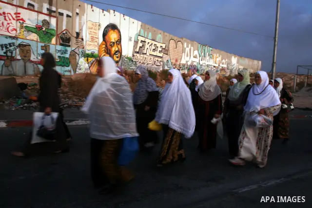 Palestinian Muslims walk towards the Israeli checkpoint of Qalandiya near the West Bank city of Ramallah on Aug. 5, 2011, before crossing into Jerusalem to attend the first Friday prayers of the holy month of Ramadan at...
