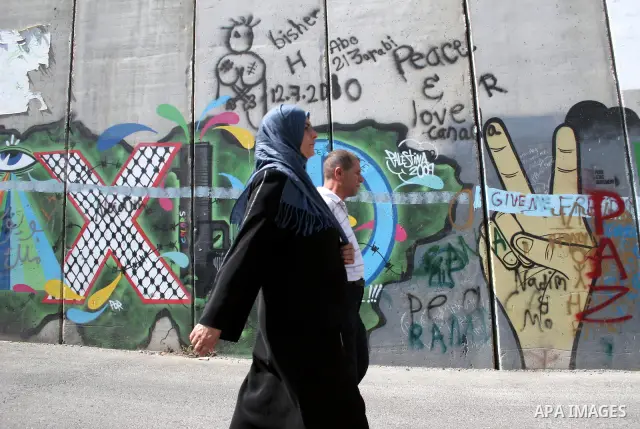 Palestinians walk in line to cross from the Qalandia checkpoint that leads from the West Bank town of Ramallah to Jerusalem on 05 August 2011, in order to attend the Friday prayers in the holy Muslim month of Ramadan at...
