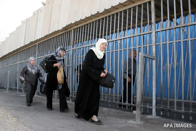Palestinian women walk in line to cross from the Qalandia checkpoint that leads from the West Bank town of Ramallah to Jerusalem on 05 August 2011, in order to attend the Friday prayers in the holy Muslim month of Ramada...