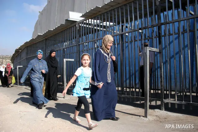 Palestinian women walk in line to cross from the Qalandia checkpoint that leads from the West Bank town of Ramallah to Jerusalem on 05 August 2011, in order to attend the Friday prayers in the holy Muslim month of Ramada...