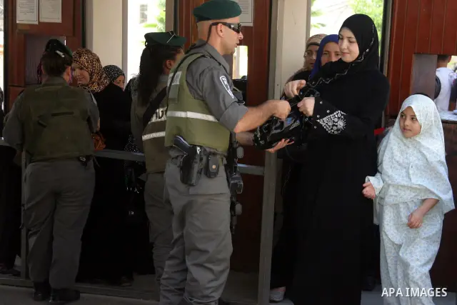 A Palestinian woman is being checked at an Israeli army checkpoint on her way to pray in the Ibrahimi Mosque in the West Bank city of Hebron, on Aug. 5, 2011. Muslims throughout the world are marking the month of Ramadan...