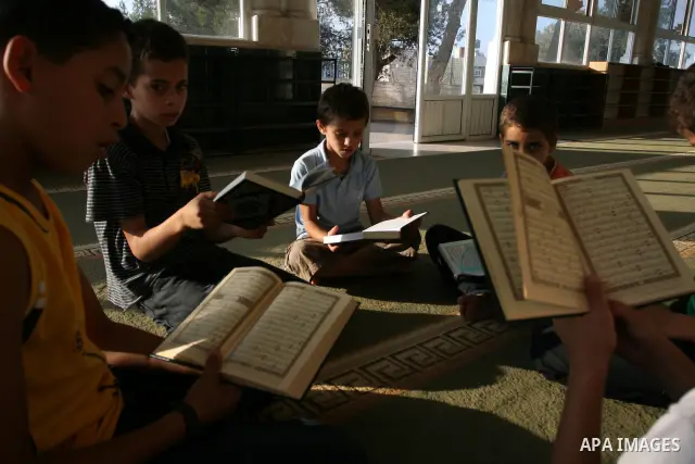 Palestinian boys read the holy Koran at the Big Mosque in the West Bank town of Ramallah, during the Muslim holy fasting month of Ramadan, on Aug. 6, 2011. Muslims throughout the world are celebrating the holy fasting mo...