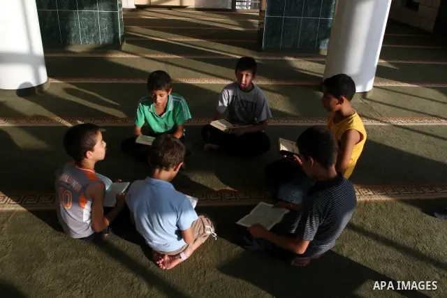 Palestinian boys read the holy Koran at the Big Mosque in the West Bank town of Ramallah, during the Muslim holy fasting month of Ramadan, on Aug. 6, 2011. Muslims throughout the world are celebrating the holy fasting mo...