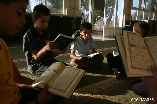 Palestinian boys read the holy Koran at the Big Mosque in the West Bank town of Ramallah, during the Muslim holy fasting month of Ramadan, on Aug. 6, 2011. Muslims throughout the world are celebrating the holy fasting mo...