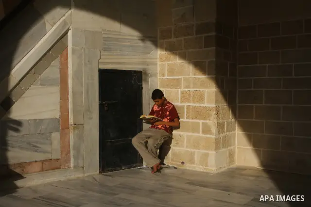 A Palestinian boy reads the holy Koran at al-Omari Mosque in Gaza city, during the Muslim holy fasting month of Ramadan, on Aug. 6, 2011. Muslims throughout the world are celebrating the holy fasting month of Ramadan, th...