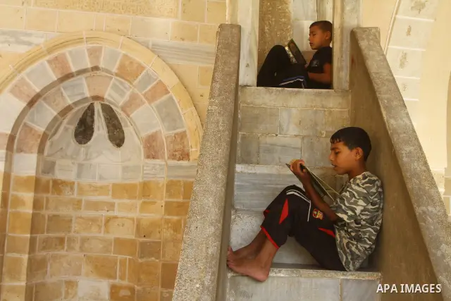 Palestinian boys read the holy Koran at al-Omari Mosque in Gaza city, during the Muslim holy fasting month of Ramadan, on Aug. 6, 2011. Muslims throughout the world are celebrating the holy fasting month of Ramadan, the...