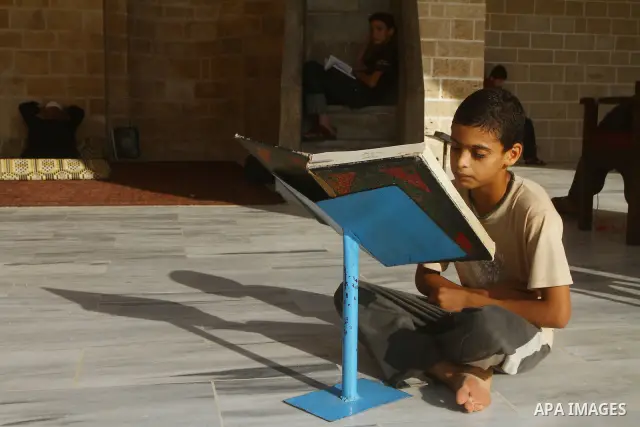 A Palestinian boy reads the holy Koran at al-Omari Mosque in Gaza city, during the Muslim holy fasting month of Ramadan, on Aug. 6, 2011. Muslims throughout the world are celebrating the holy fasting month of Ramadan, th...