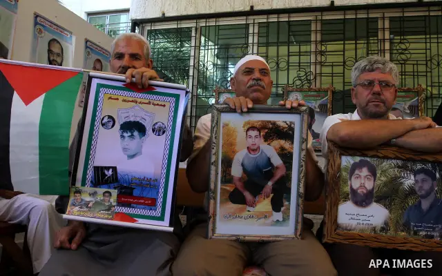 Palestinians hold pictures of their prisoned relatives in Israeli jails as they gather in a weekly activity calling for their liberty at the Red Cross headquarters in Gaza City on Aug. 8, 2011. About 7000 prisoners are i...