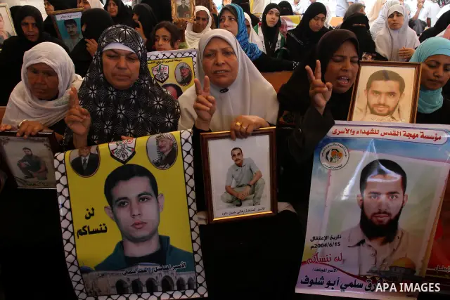 Palestinian women hold pictures of their prisoned relatives in Israeli jails as they gather in a weekly activity calling for their liberty at the Red Cross headquarters in Gaza City on Aug. 8, 2011. About 7000 prisoners...