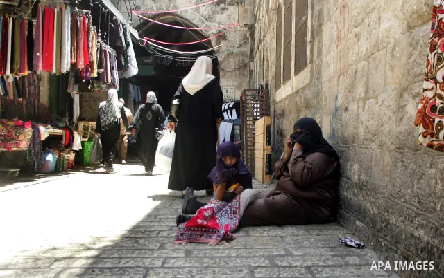 A Palestinian poor woman, sits on the floor asking for money at a market in the holiest month of Ramadan in the old city of Jerusalem on Aug. 8, 2011. Muslims throughout the world are marking the month of Ramadan, during...