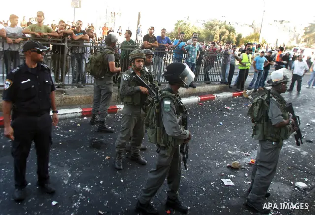 Israeli border guard keep watch Palestinians as they shop at a market, in the old city of Jerusalem on Aug. 8, 2011. Muslims throughout the world are marking the month of Ramadan, during which they refrain from eating, d...