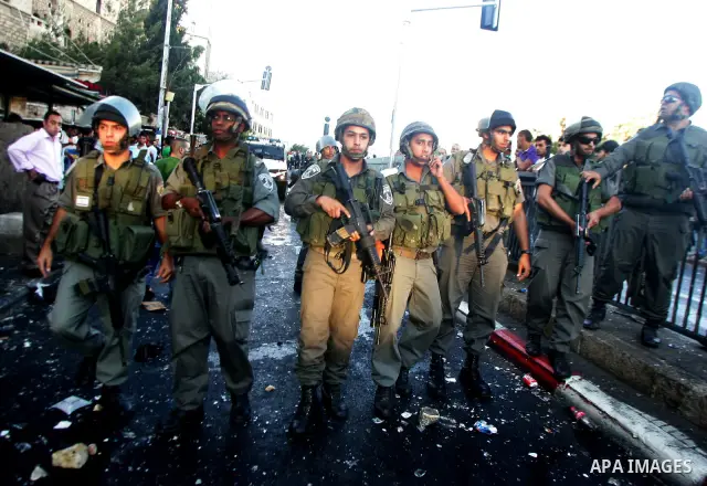 Israeli border guard keep watch Palestinians as they shop at a market, in the old city of Jerusalem on Aug. 8, 2011. Muslims throughout the world are marking the month of Ramadan, during which they refrain from eating, d...