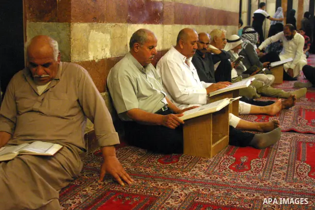 Palestinian men read the holy Koran at the Ibrahimi Mosque in the West Bank city of Hebron,on Aug. 8, 2011. Muslims around the world are observing the fasting month of Ramadan during which they refrain from eating, drink...