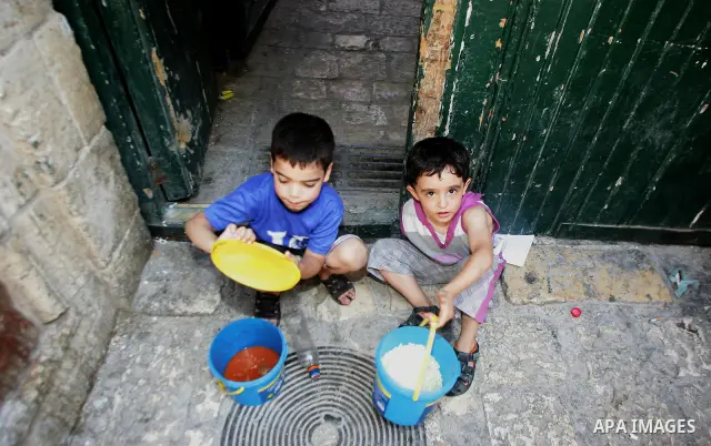 Palestinian children receive food rations on August 8,2011 distributed by the Waqf, a Jordanian-backed body that oversees Muslim holy sites in Jerusalem, on the second week of the fasting month of Ramadan in Jerusalem's...