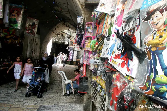 Palestinians are seen silhouetted at the entrance of the brightly lit Al-Aqsa mosque compound, in the old city of Jerusalem, during the holy month of Ramadan. 8 August 2011. Photo by Mahfouz Abu Turk