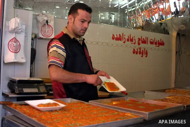 A Palestinian worker displays traditional sweets popular during the Muslim holy month of Ramadan in the West Bank city of Hebron Aug. 9, 2011. Muslims around the world abstain from eating, drinking and conducting sexual...