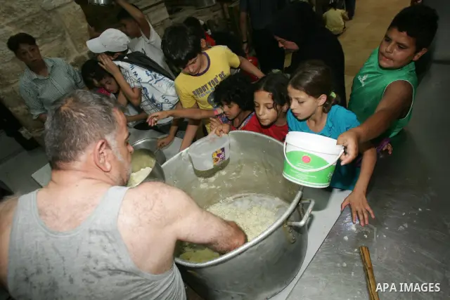 Palestinian children receive food rations on August 9,2011 distributed by the Waqf, a Jordanian-backed body that oversees Muslim holy sites in Jerusalem, on the second week of the fasting month of Ramadan in Jerusalem's...
