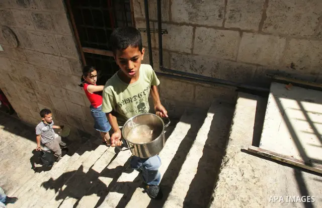 Palestinian children receive food rations on August 9,2011 distributed by the Waqf, a Jordanian-backed body that oversees Muslim holy sites in Jerusalem, on the second week of the fasting month of Ramadan in Jerusalem's...
