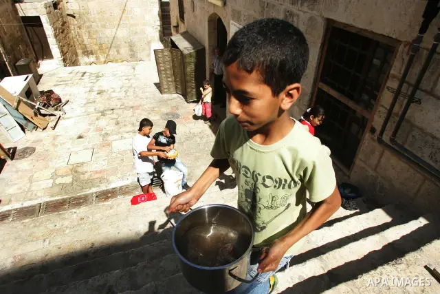 Palestinian children receive food rations on August 9,2011 distributed by the Waqf, a Jordanian-backed body that oversees Muslim holy sites in Jerusalem, on the second week of the fasting month of Ramadan in Jerusalem's...
