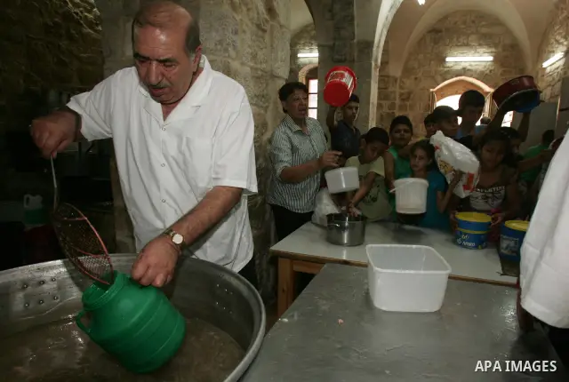 Palestinian children receive food rations on August 9,2011 distributed by the Waqf, a Jordanian-backed body that oversees Muslim holy sites in Jerusalem, on the second week of the fasting month of Ramadan in Jerusalem's...