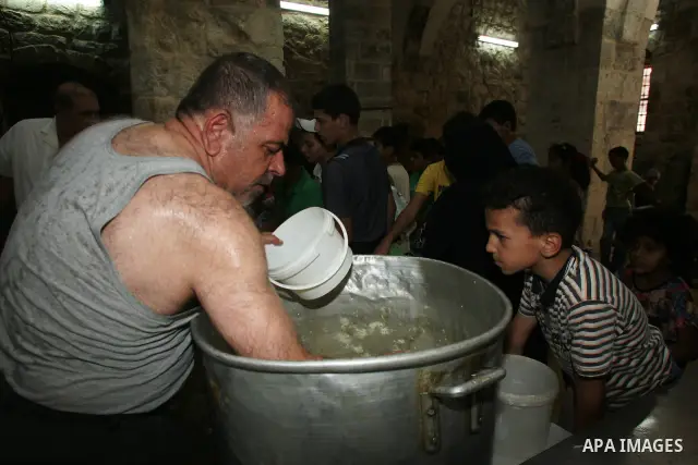 Palestinian children receive food rations on August 9,2011 distributed by the Waqf, a Jordanian-backed body that oversees Muslim holy sites in Jerusalem, on the second week of the fasting month of Ramadan in Jerusalem's...