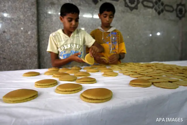 Palestinian boys prepare qatayef, a popular sweet to sell it during Ramadan, at a shop in Gaza city on Aug.10, 2011. Muslims around the world are observing the holy fasting month of Ramadan where they refrain from eating...