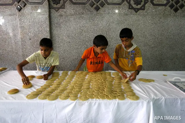 Palestinian boys prepare qatayef, a popular sweet to sell it during Ramadan, at a shop in Gaza city on Aug.10, 2011. Muslims around the world are observing the holy fasting month of Ramadan where they refrain from eating...