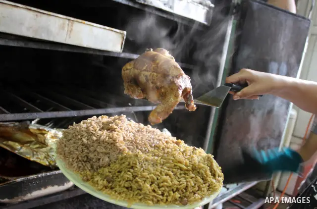 Palestinian bakers prepare chicken and rice 'Qedrah" in a traditional stove at Beirut Kitchen in Gaza city on Aug. 10, 2011, during the holy fasting month of Ramadan, when observant Muslims abstain from eating, drinking...
