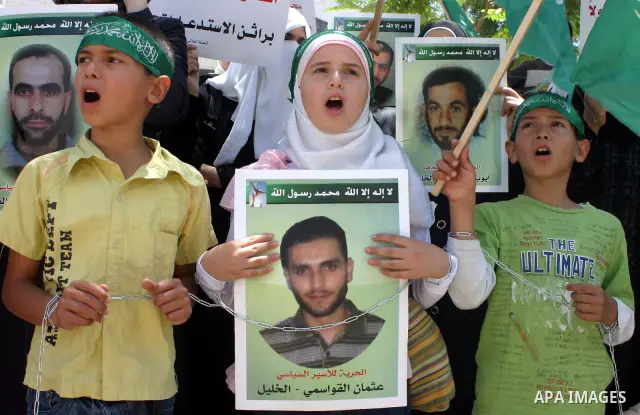 Palestinian Hamas supporters hold pictures of relatives who were arrested and imprisoned for political reasons by Palestinian Authority security forces, during a protest in the West Bank city of Hebron on Aug. 11, 2011....