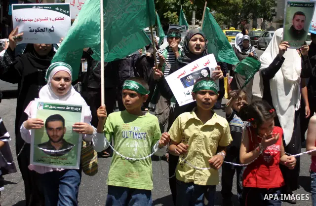 Palestinian Hamas supporters hold pictures of relatives who were arrested and imprisoned for political reasons by Palestinian Authority security forces, during a protest in the West Bank city of Hebron on Aug. 11, 2011....